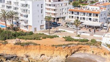 Eine Küstenstadt mit modernen Gebäuden, einem Strand und klarem Wasser.
