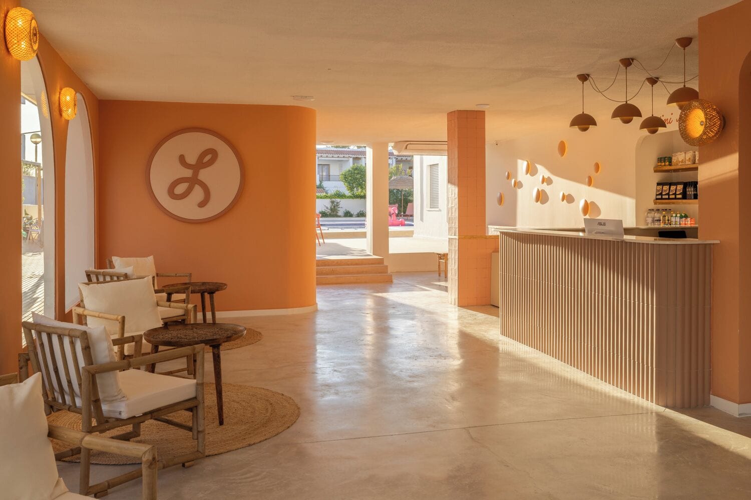 Eine Hotelhalle mit einer Rezeption, einer Sitzgruppe und einer großen Wand mit einem kreisförmigen Design.