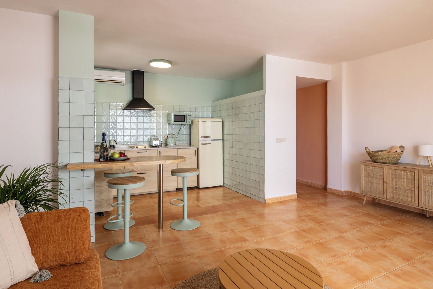 Een moderne keuken met een magnetron, fornuis en barkrukken.