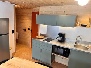 A compact kitchen with a built-in microwave, a coffee maker, and a sink.