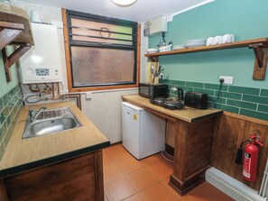 A compact kitchen with a sink, a small refrigerator, a toaster, and a coffee maker. - Cabin No. 6 - Salt and Fern Cabins (Port Talbot)