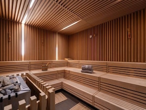 A sauna with wooden benches and a stone basin. - 4 Star Holiday Home in Travemunde (Lübeck)