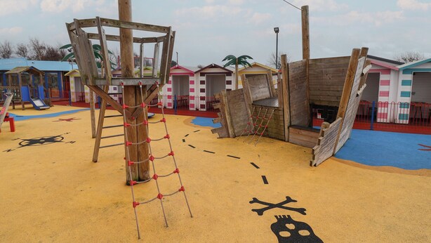 Ein Spielplatz mit Klettergerüst, Rutschen und Sandkasten.