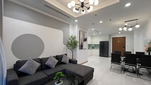Uma sala de estar moderna com sofá, mesa de centro e área de jantar com cadeiras.