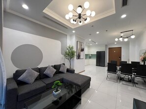 A modern living room with a sofa, coffee table, and dining area with chairs. - 2 Bedroom Apartment for Rent at Vinhomes Central Park (Thành phố Hồ Chí Minh)