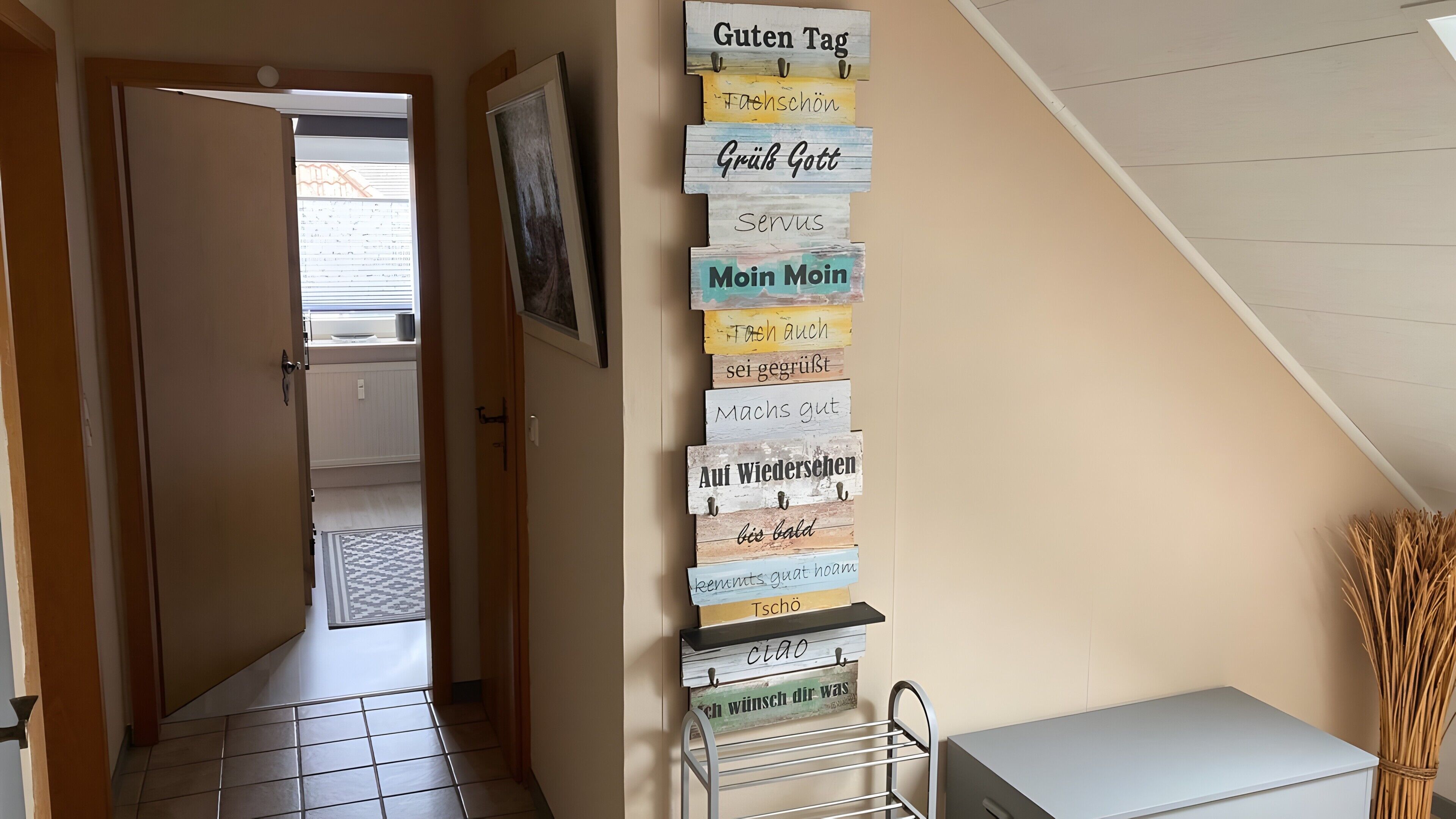 Käytävällä on pystysuorassa oleva puinen kyltti, jossa on useita saksankielisiä lauseita.