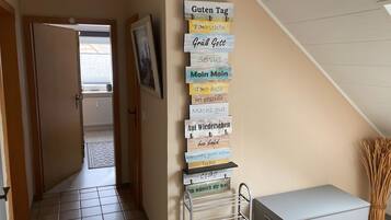 Un couloir orné d’un panneau en bois vertical sur lequel figurent différentes expressions en allemand.