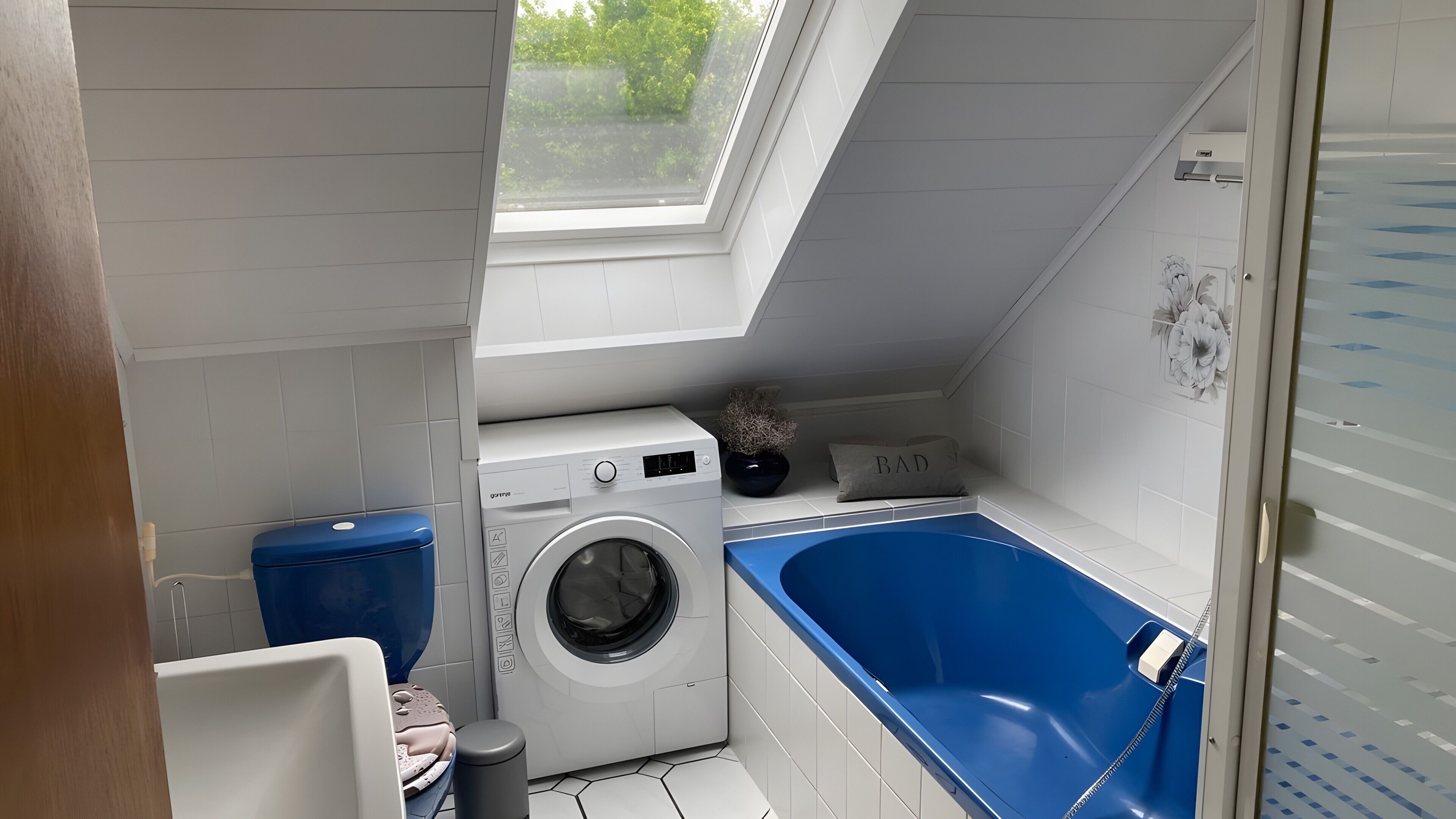 Ein kompakter Waschraum mit Waschmaschine, einer blauen Badewanne und einem Oberlicht.