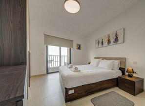 A bedroom with a bed, bedside table, and artwork on the wall. - Stylish 2BR Retreat w/ Balcony & Fast WiFi (Msida)