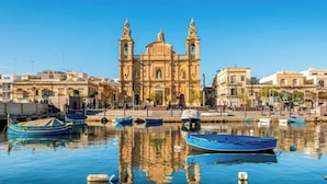 A historic building with two towers, a waterfront, and several boats. - Stylish 2BR Retreat w/ Balcony & Fast WiFi (Msida)