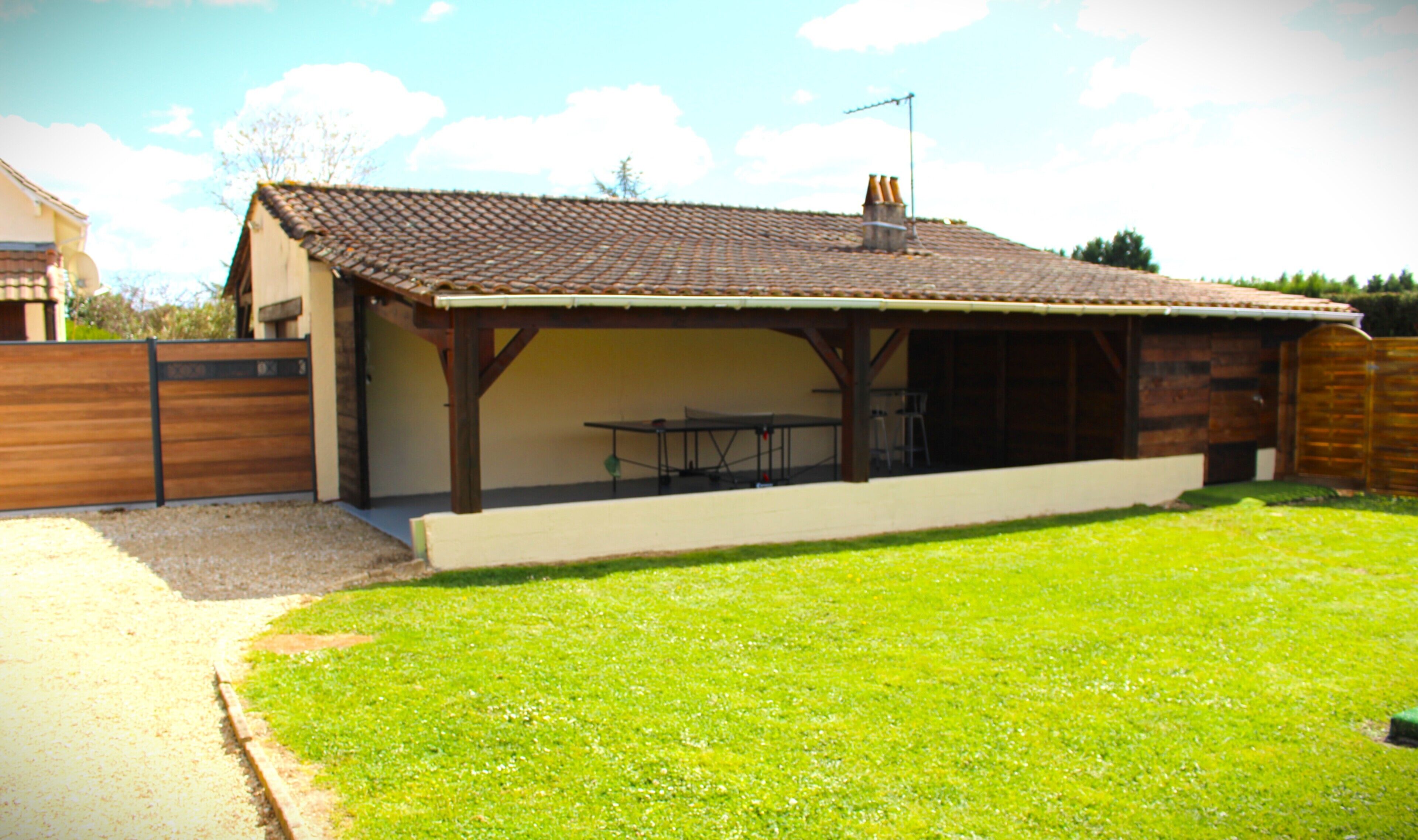 A house with a covered patio, a fenced yard, and a grassy lawn.