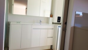 Eine moderne Küche mit weißen Schränken, einer Arbeitsplatte und einem eingebauten Backofen.