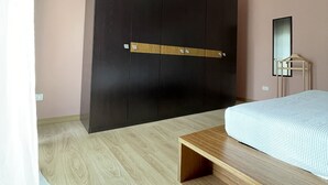 Un dormitorio con una cama, un banco de madera, un armario y un espejo.