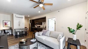 Un salon moderne avec un canapé, une table basse et un ventilateur de plafond.