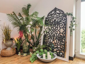 A room with a decorative black partition, various potted plants, a Buddha statue, and a candle holder. - The Retreat (Goole)