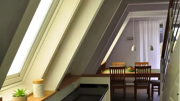A modern kitchen with a skylight, wooden dining table, and chairs. - Holiday Home 'Meinhaus-damp' with Terrace, Garden and Wi-Fi (Damp)