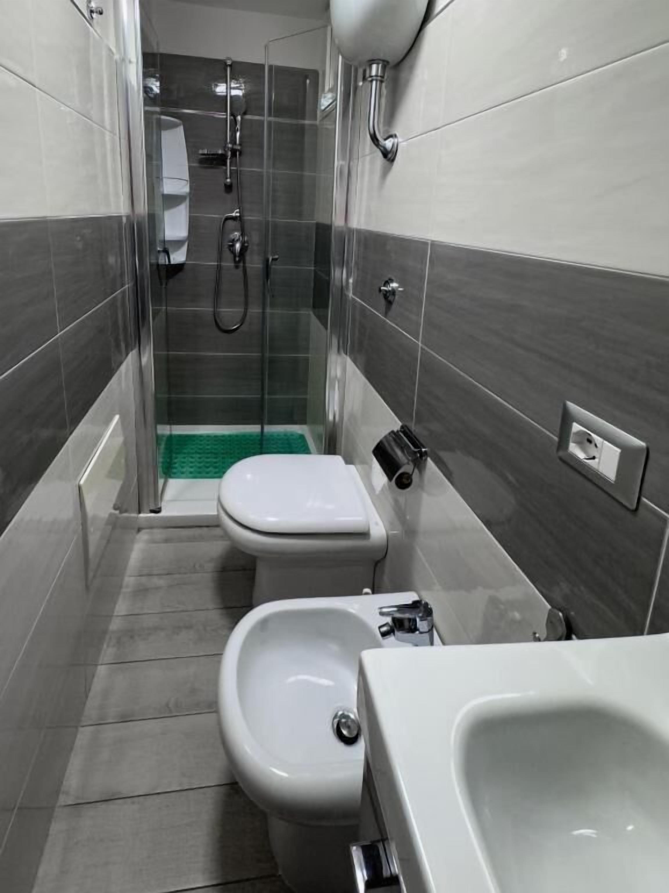 Une salle de bain équipée de toilettes, d’un bidet et d’une douche.