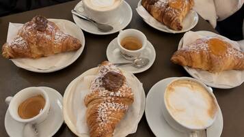 A table with croissants and cups of coffee.