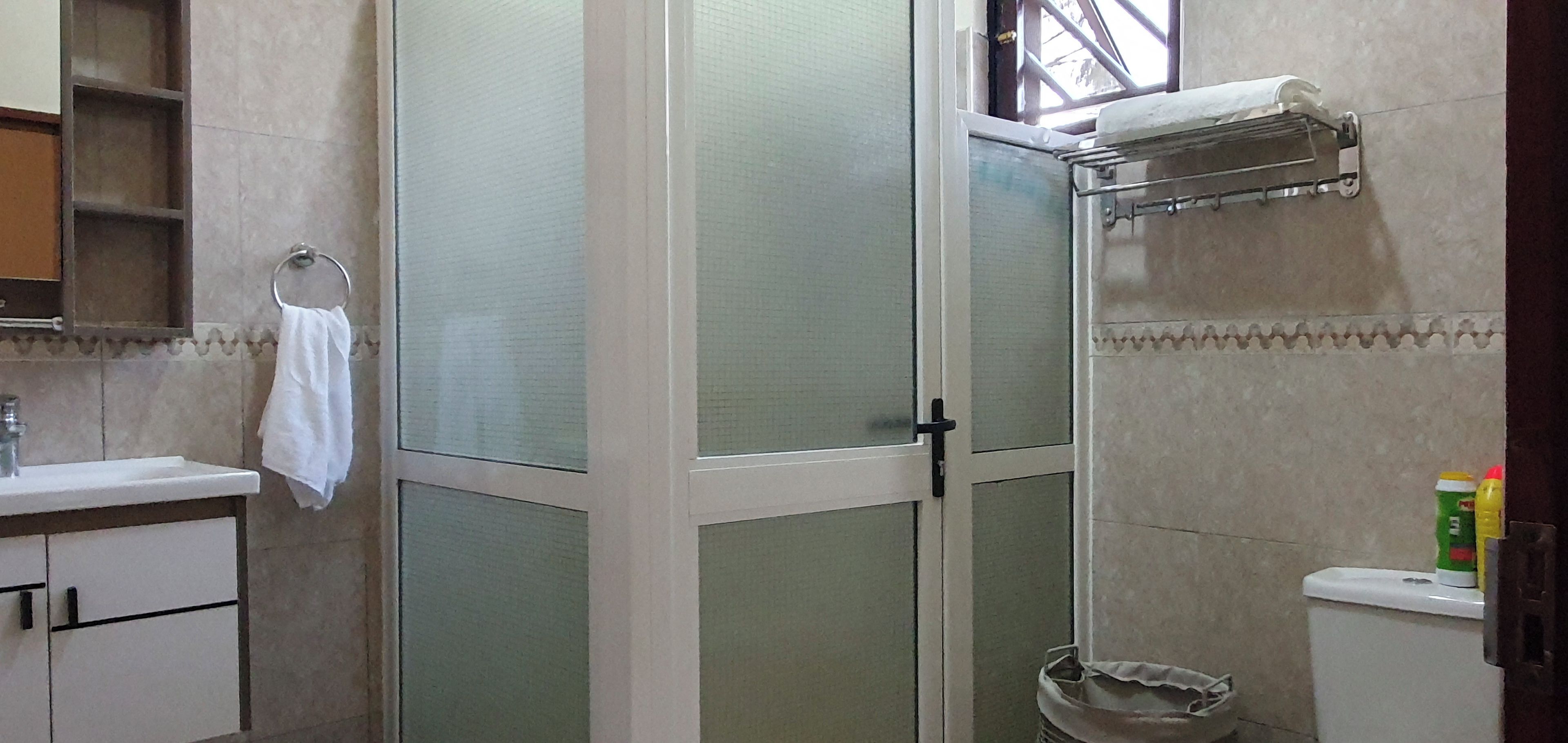 A bathroom with a shower, toilet, and sink.