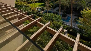 A residential building with a pool, palm trees, and a clear sky. - ELITE New Modern 3BR Apartment (New Cairo)