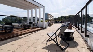 A rooftop terrace with outdoor seating, a pergola, and a view of the cityscape. - 4 Star Holiday Home in Travemunde (Lübeck)