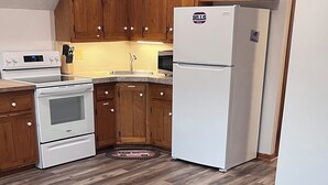 Una cocina moderna con armarios de madera, un refrigerador blanco y un horno empotrado.