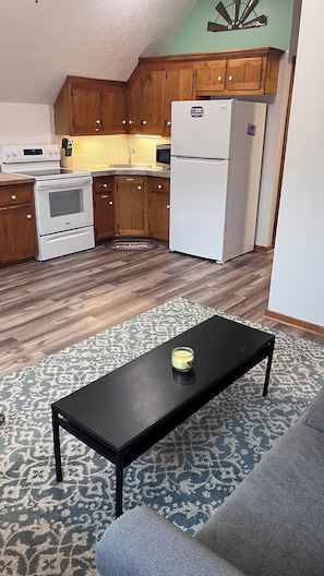 Una cucina moderna con mobili in legno, un frigorifero bianco e un forno integrato.