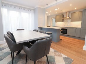 A modern kitchen with grey cabinets, a marble countertop, and a central island. - Marilyn (Morecambe)