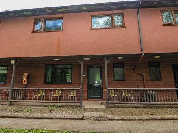 A two-story building with a porch, multiple windows, and a door. - Cabin No. 12 - Salt and Fern Cabins (Port Talbot)