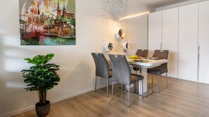 A modern dining area with a table, chairs, and a potted plant. - Apartment 'Lubeca' with Loggia (Goslar)