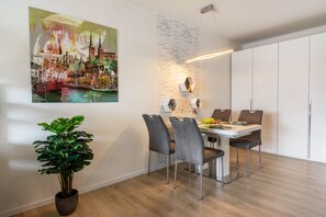 Un espace repas moderne avec une table, des chaises et une plante en pot.