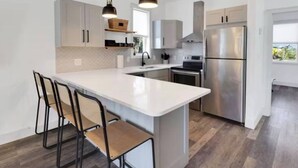 Een moderne keuken met een centraal eiland, roestvrijstalen apparatuur en een minimalistisch ontwerp.