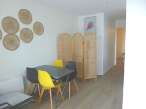 A dining area with a table, chairs, and a decorative wall. - House With Breathtaking View of the Lake (Lacanau)