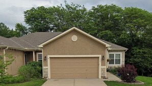 A residential house with a garage, a driveway, and a lawn. - Azura Amphitheater Home — Sleeps 6 (Kansas City)