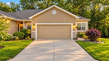 A residential house with a garage, a driveway, and a well-maintained lawn.