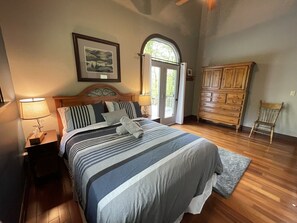 Ein Schlafzimmer mit einem Bett, Nachttischen, einem Schminktisch und einem Sessel.