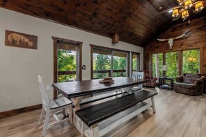 A wooden interior with a dining table, benches, and a sofa. - Gatlinburg 7BR | Swim Spa + Sauna (Gatlinburg)