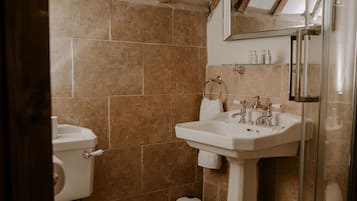 A bathroom with a toilet, sink, and shower.