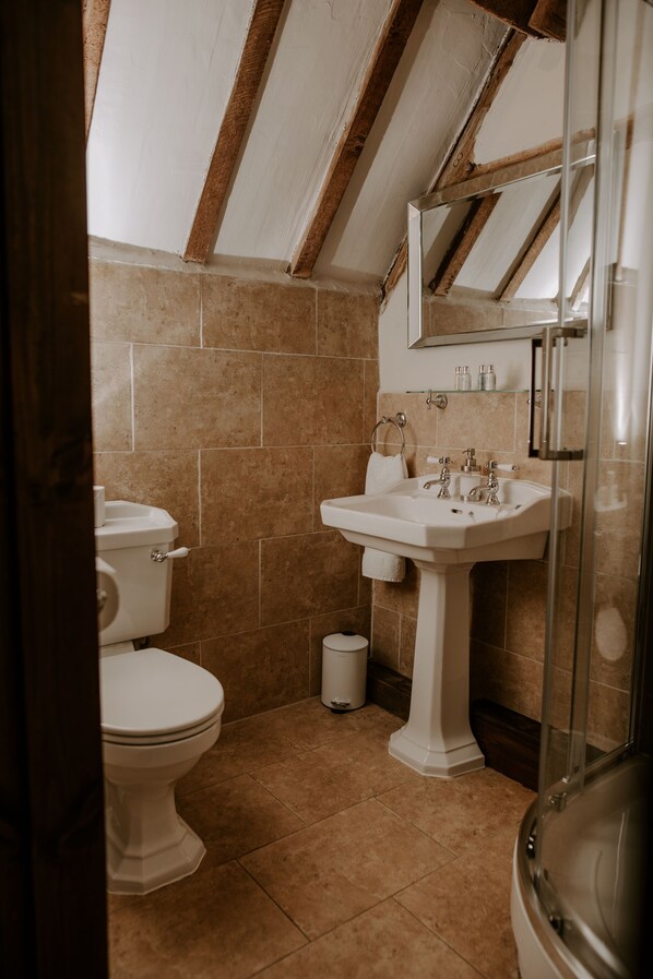 A bathroom with a toilet, sink, and shower. - Allington Manor (Allington)