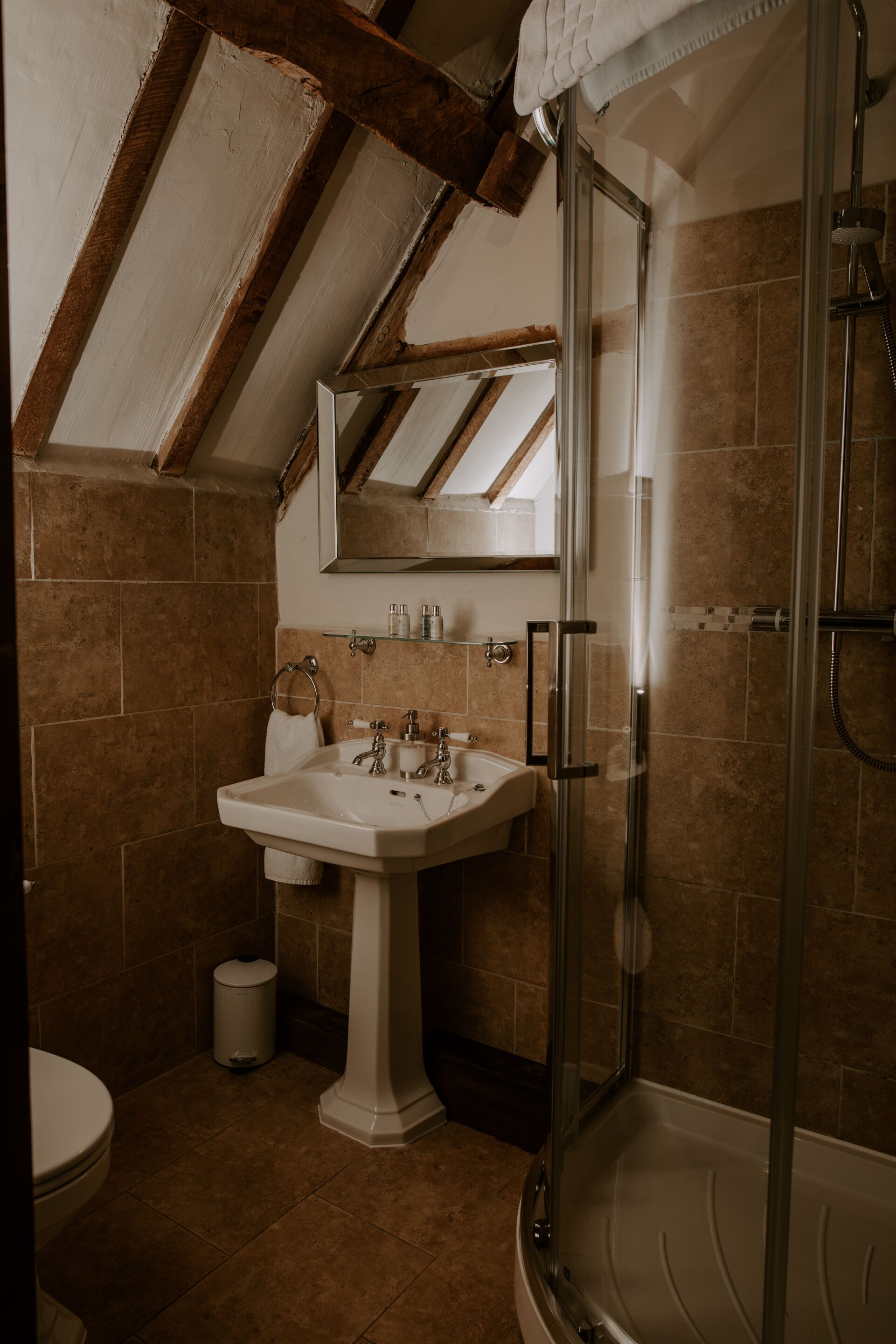 A bathroom with a shower, sink, and toilet.
