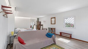 A room with a bed, a bench, a small table, and a window. - Portas de Caminha III Studio with Shared Terrace, Balcony and Wi-Fi (Caminha)