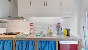 A kitchen with white cabinets, a stainless steel sink, a dishwasher, and a countertop with various items. - Portas de Caminha III Studio with Shared Terrace, Balcony and Wi-Fi (Caminha)