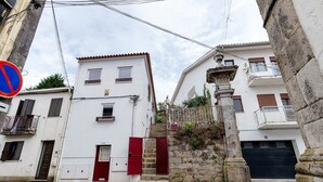 Una calle estrecha con edificios blancos, una señal de prohibido estacionar y una puerta roja.