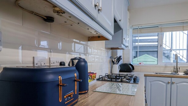 Una cocina moderna con estufa a gas, armarios y una ventana.