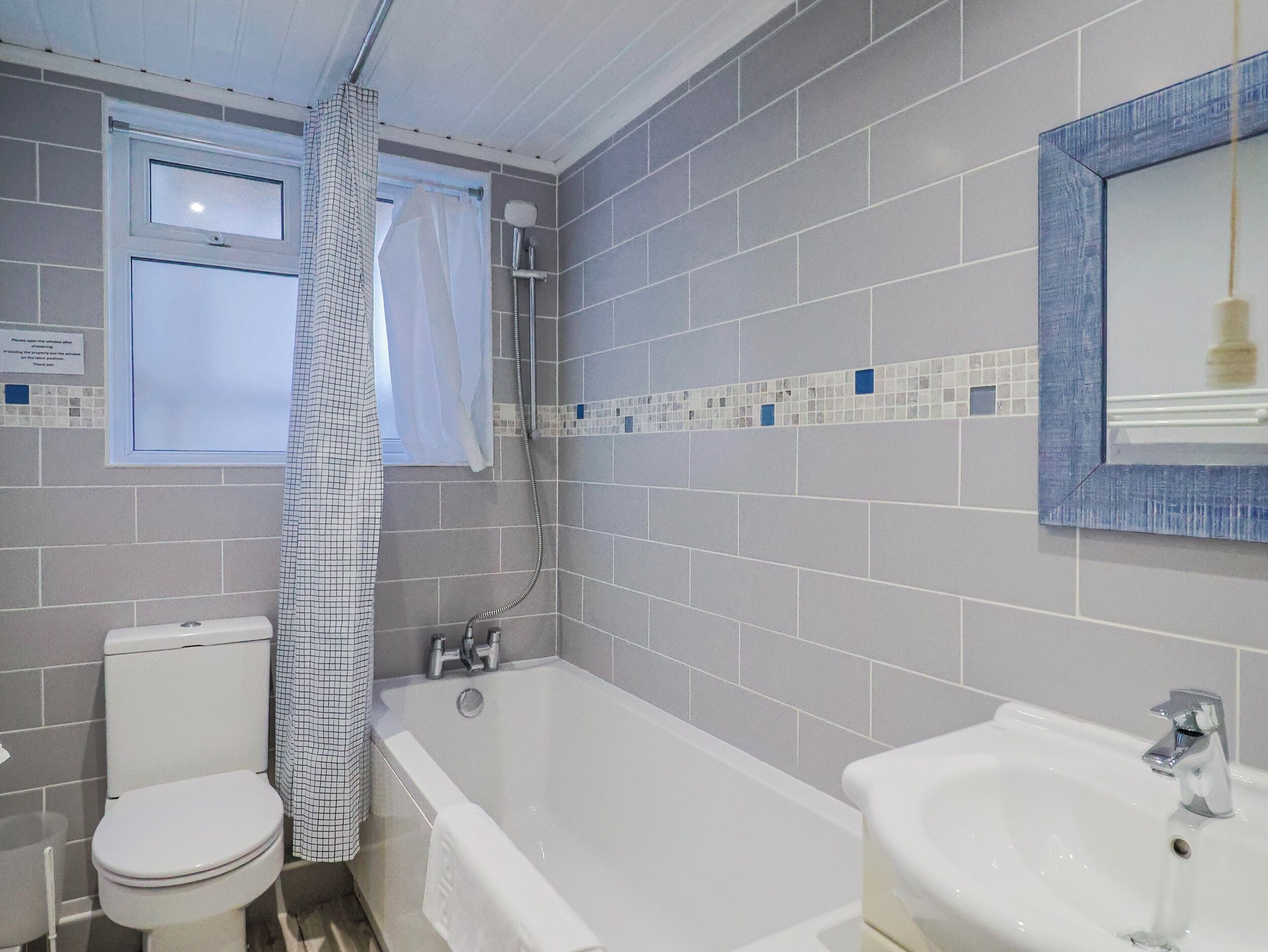 A bathroom with a toilet, bathtub, and sink.