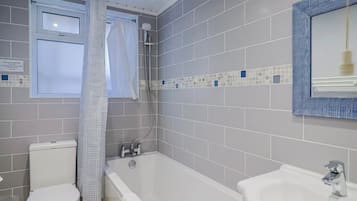 A bathroom with a toilet, bathtub, and sink.