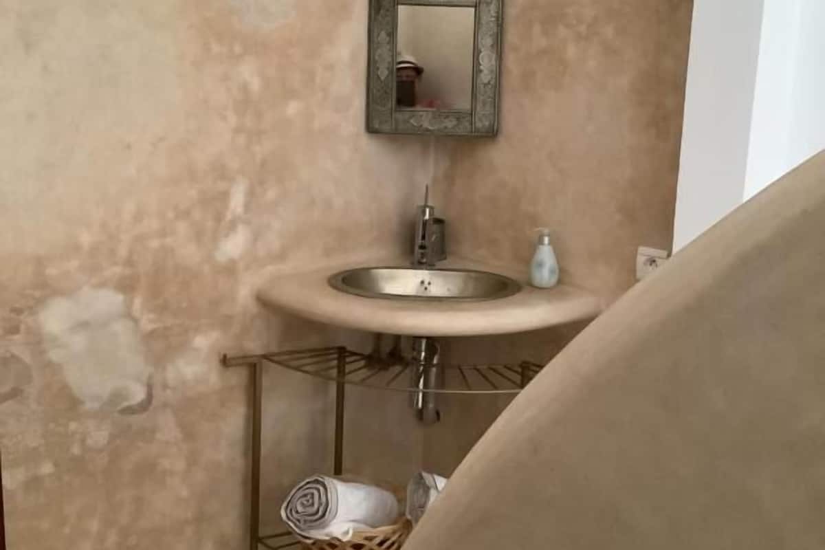 A bathroom with a sink, mirror, and towel rack.