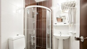 A bathroom with a glass-enclosed shower, a toilet, a sink, and a towel rack. - Dınar Hotel (Istanbul)