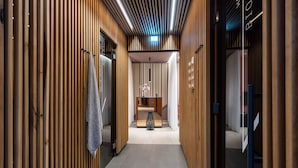 A corridor with wooden paneling, a towel rack, a small table with flowers, and a sign with text. - 4 Star Holiday Home in Travemunde (Lübeck)