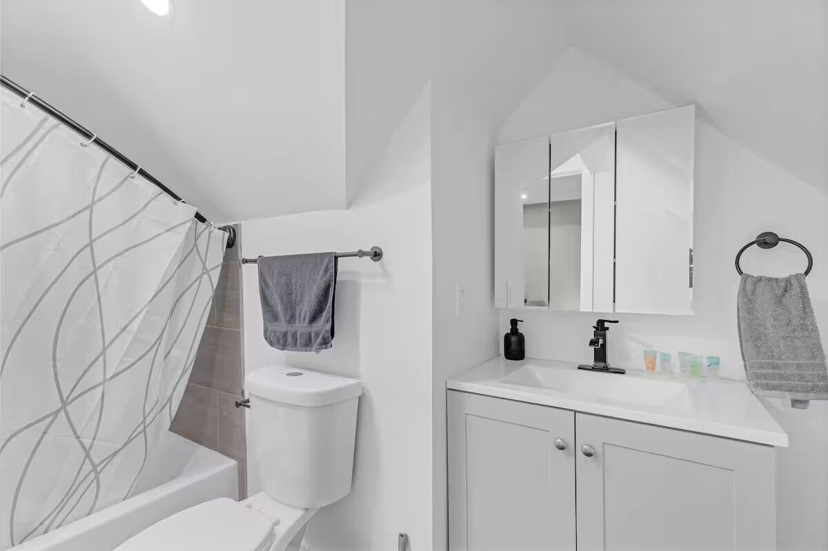 A modern bathroom with a toilet, sink, and shower.